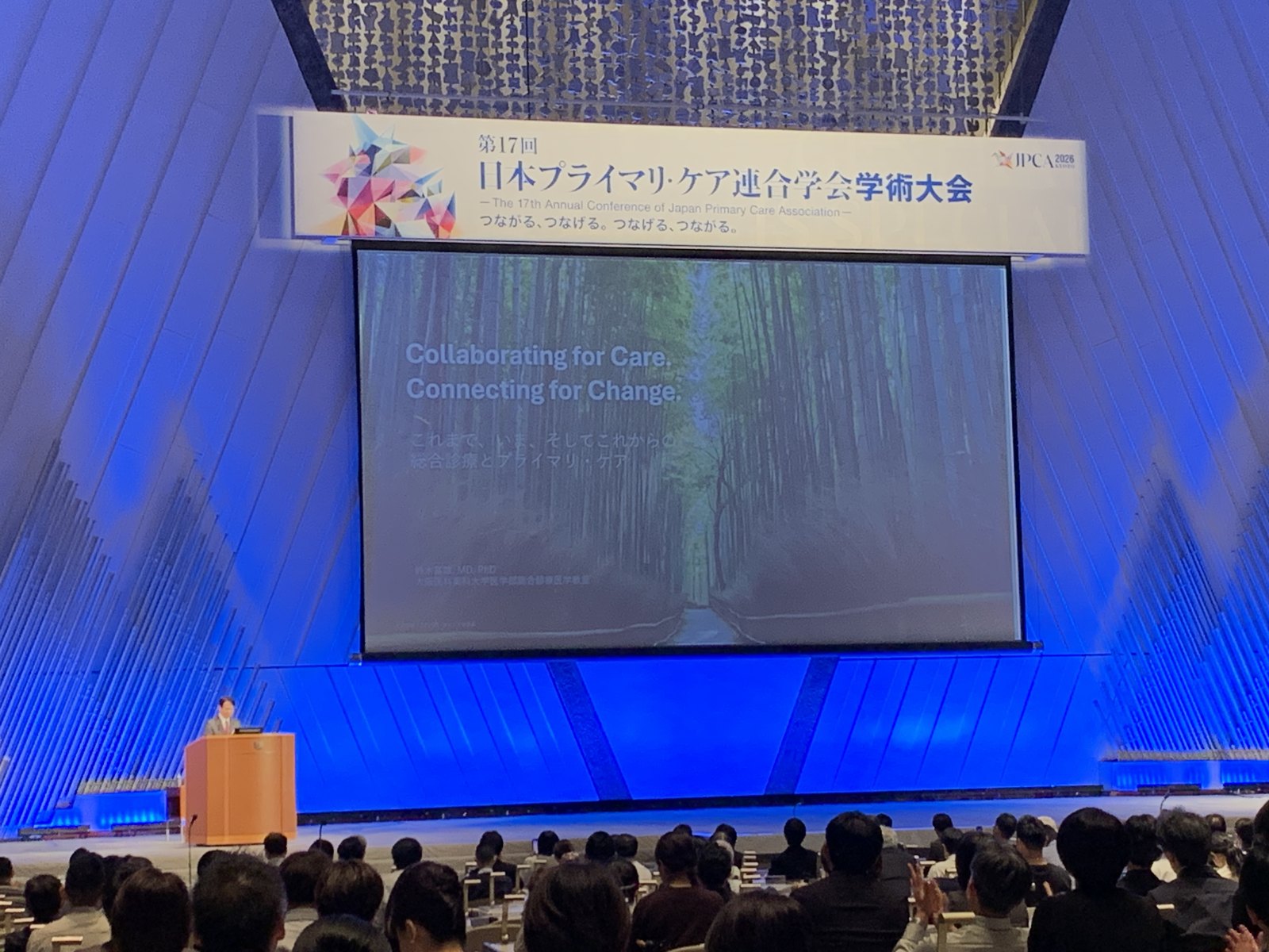 The conference theme on the main stage screen: Collaborating for Care. Connecting for Change.