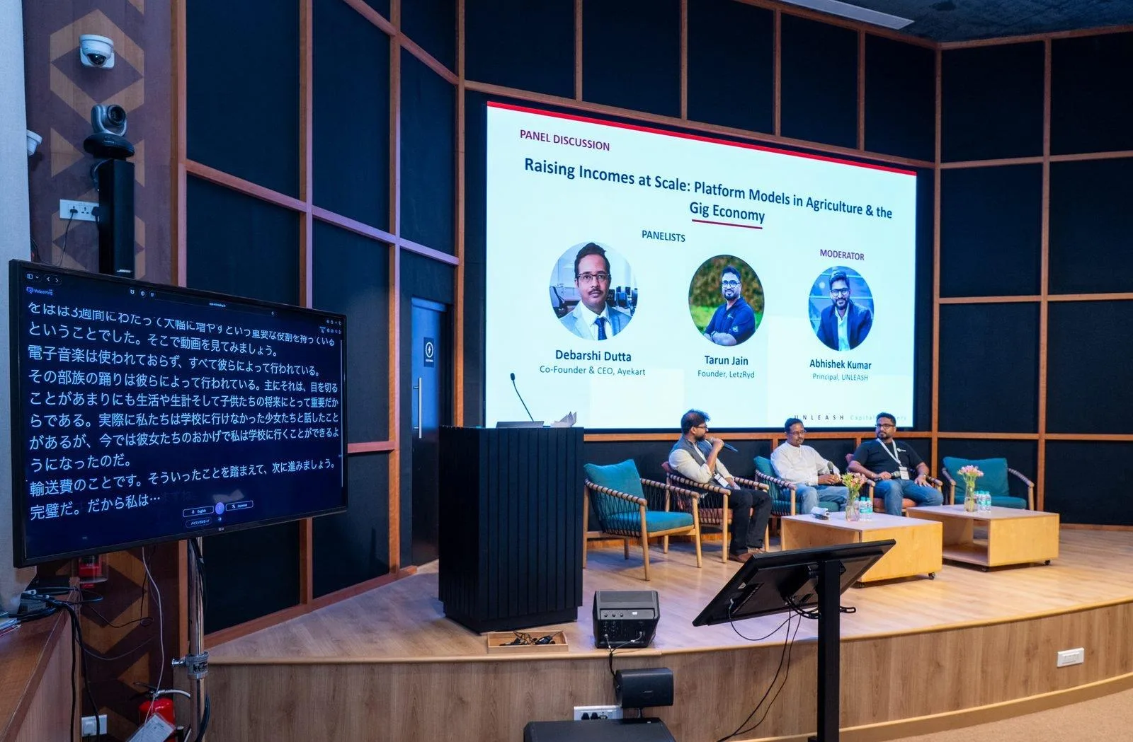 Panel discussion with VoicePing translation shown on an in-room monitor